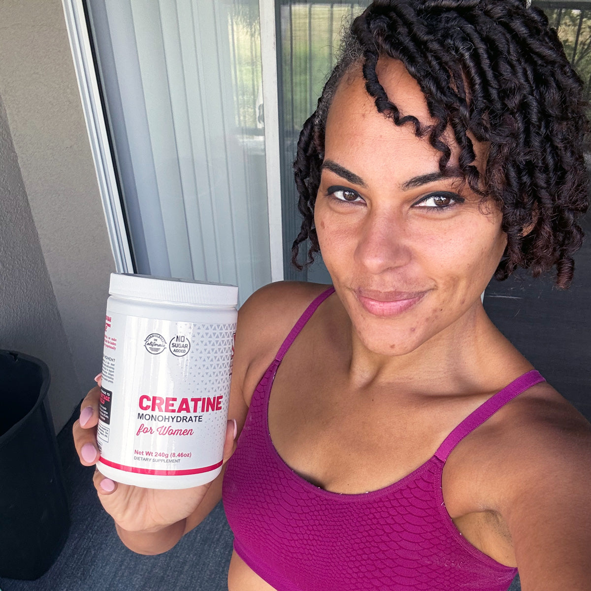 Woman holding bottle of creatine