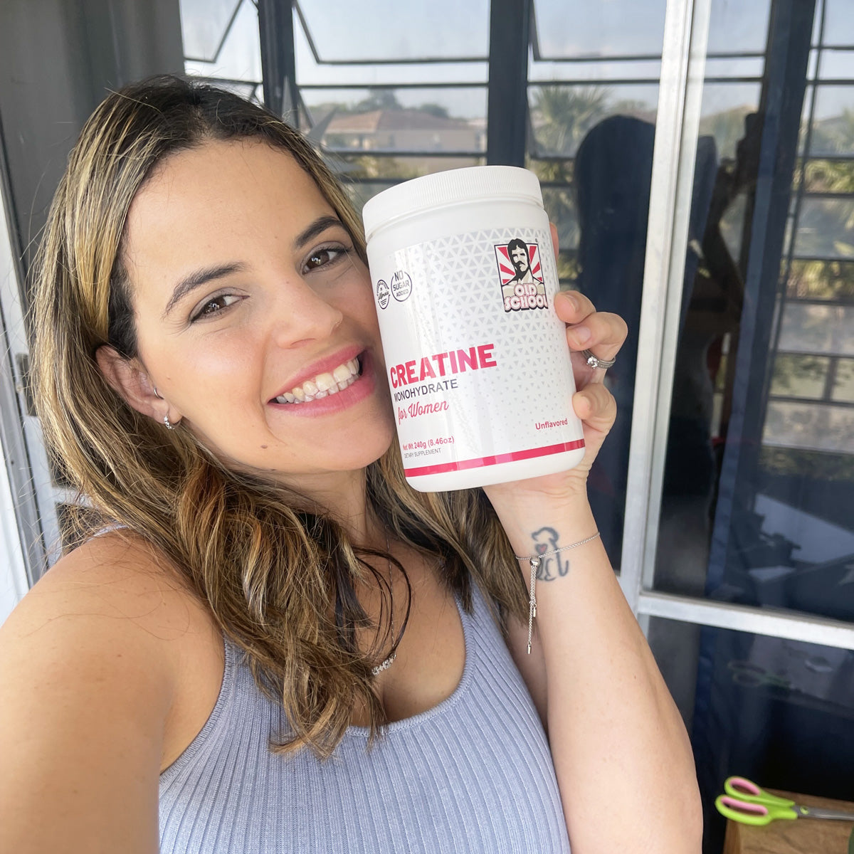 Woman holding bottle of creatine