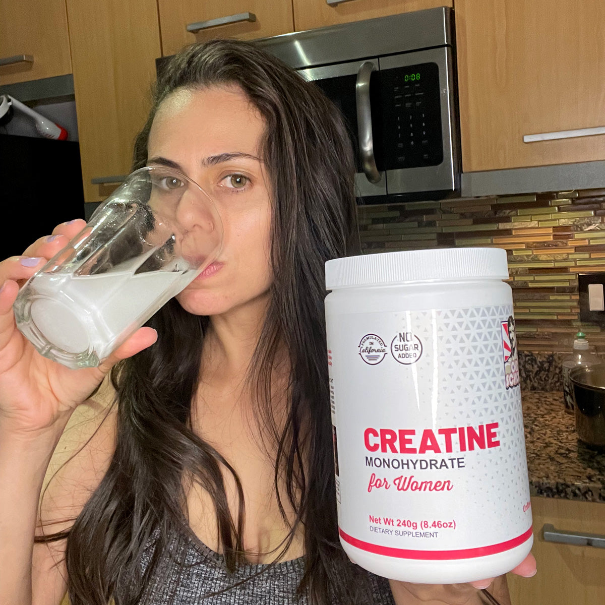 Woman drinking glass of creatine